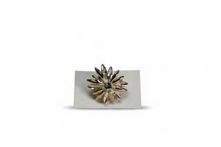 A two-tone gold and silver flower-shaped brooch with a clear rhinestone center, displayed on a small white card against a textured white fabric background.