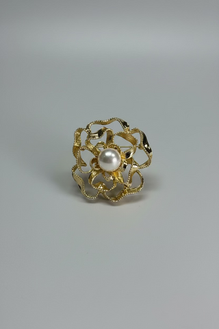 , displayed on a small white card against a textured white fabric background.