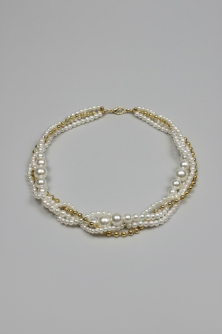 A multi-strand pearl necklace with gold-toned spacer beads and a gold clasp