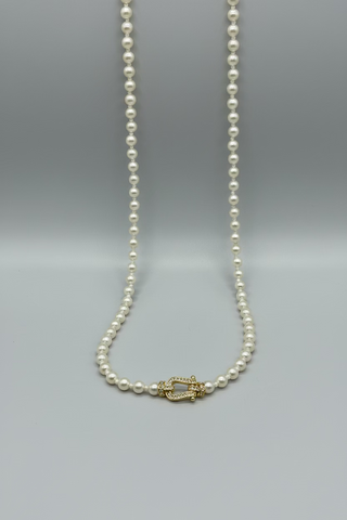 A pearl necklace with a gold-tone horseshoe clasp