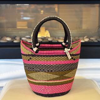 Woven handbag with pink and brown stripes on a white surface