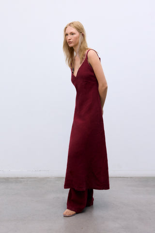 Woman wearing a burgundy dress against a white background