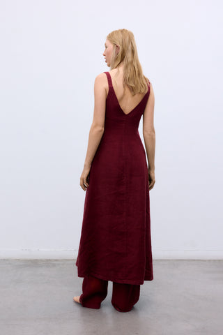 Woman wearing a burgundy dress with a plain white background