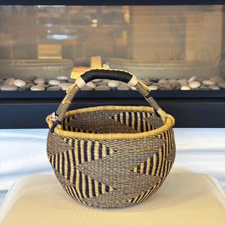 Woven basket with striped pattern on a white surface
