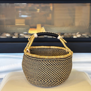 Woven basket with a handle on a white surface with a blurred background