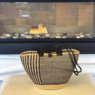 Woven basket with black and beige pattern on a white surface