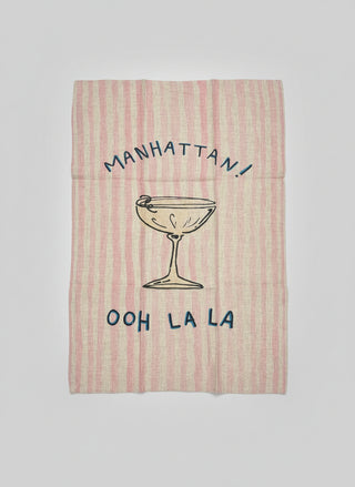 Tea towel with Manhattan cocktail graphic and text on a light background