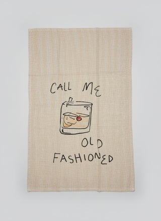 Tea towel with drawing of a glass of whiskey and text 'Call Me Old Fashioned' on a textured surface.